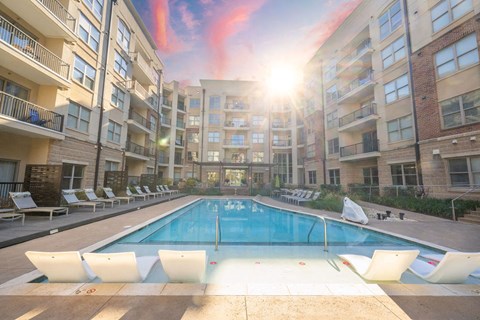 an apartment pool in front of an apartment building