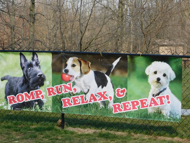 a sign with three dogs on it on a fence