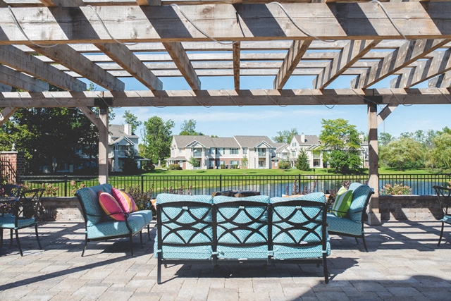 a pergola on a patio with a table and chairs