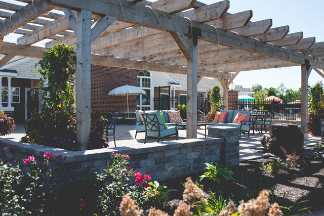a patio with a pergola and a fire pit