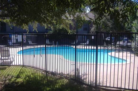 A pool surrounded by a black fence.