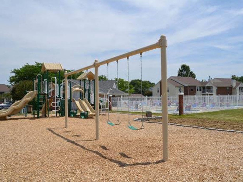 a playground with swings and other toys in a park