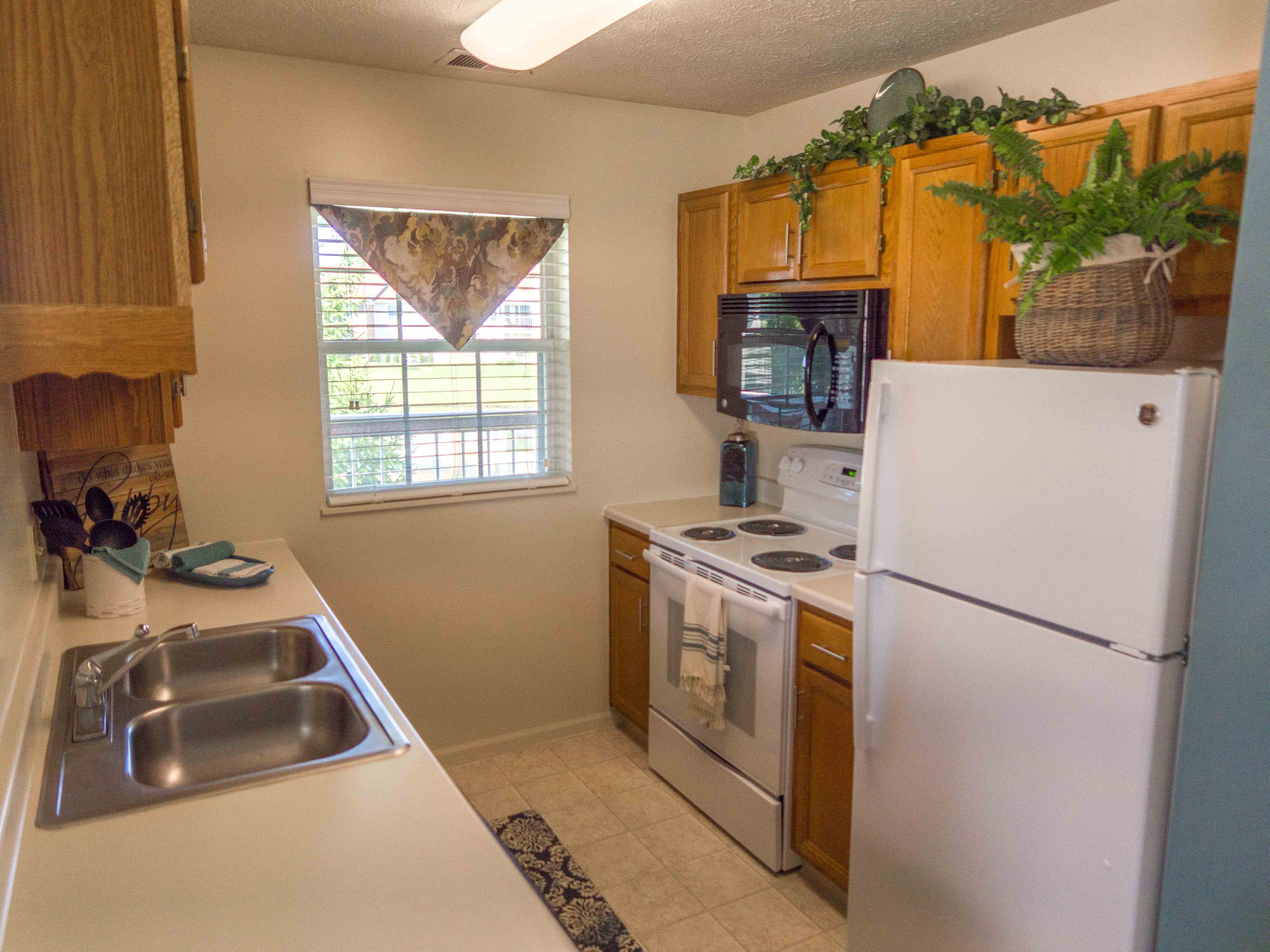 a kitchen with white appliances and wooden cabinets
