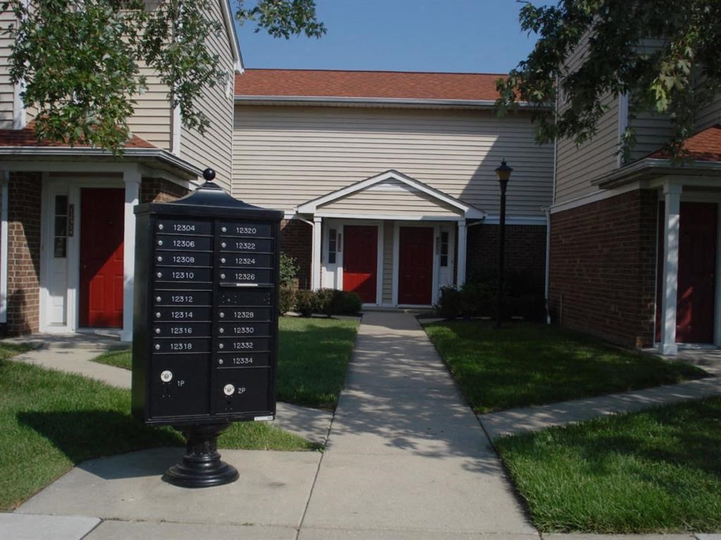 a parking meter on the sidewalk in front of a house