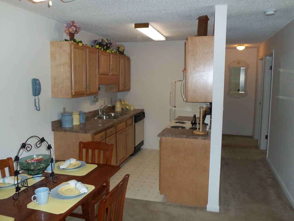 a kitchen and dining room with wooden cabinets and a table