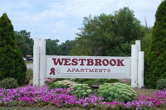 a sign apartments in front of flowers