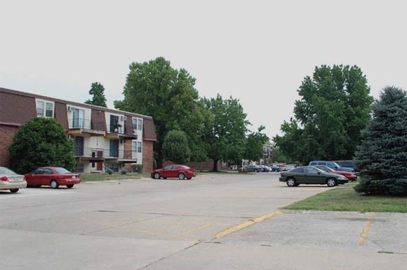 a parking lot with cars parked in front of buildings