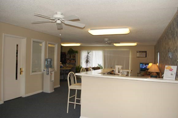 a kitchen with a bar and a ceiling fan