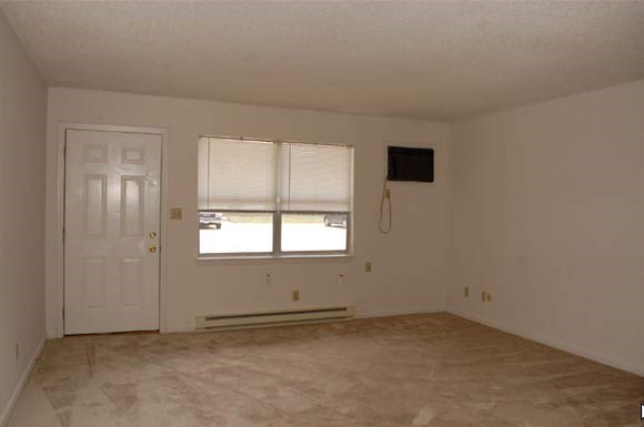 an empty living room with a window and a door