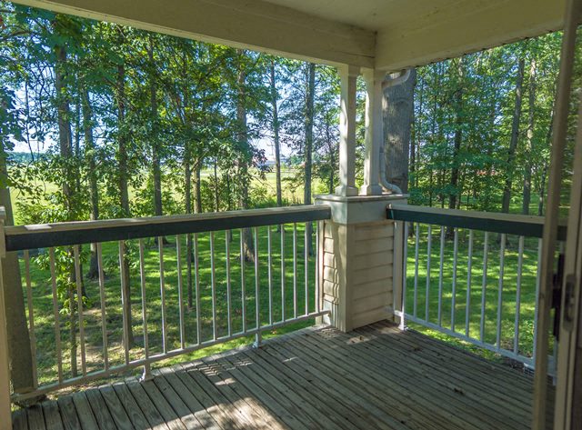 a porch with a view of a field and trees