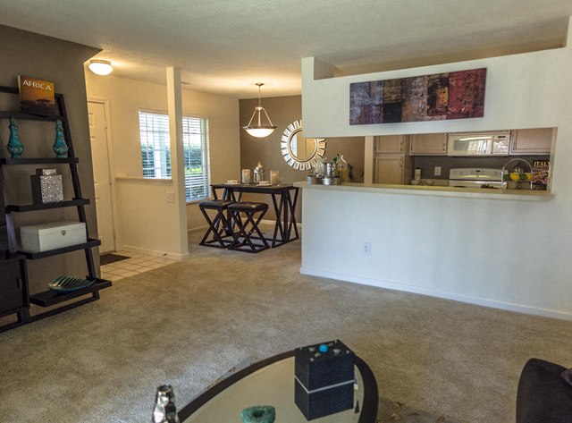 an empty living room with a kitchen and a bar