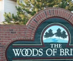 a sign for the woods of briton apartment homes