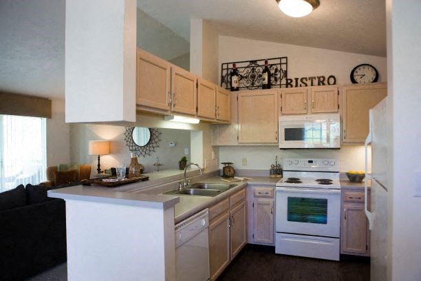 a kitchen with white appliances and wooden cabinets