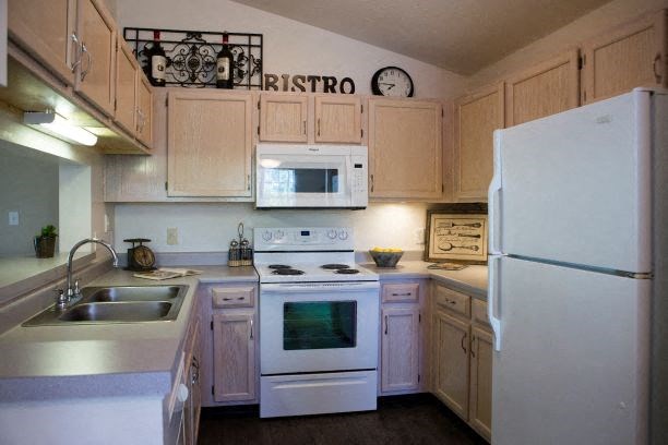 a kitchen with white appliances and wooden cabinets
