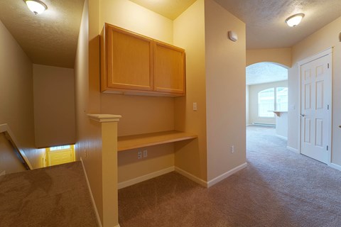 a renovated living room with a desk and cabinets