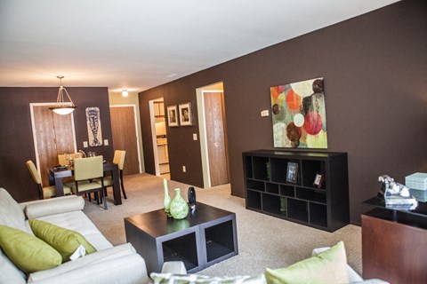 A living room with a white couch and a green pillow.