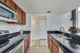 a kitchen with granite countertops and wooden cabinets