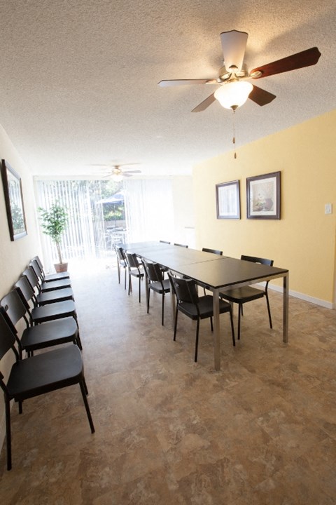 a large dining room with a large table and chairs and a ceiling fan