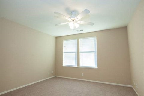 a bedroom with a ceiling fan and a window
