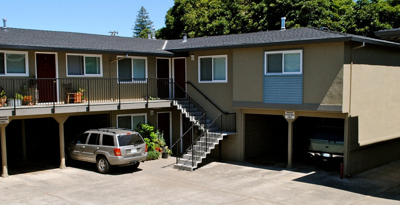 an apartment building with a car parked in a parking lot