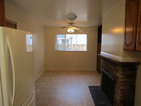 A kitchen with a white refrigerator and a ceiling fan.