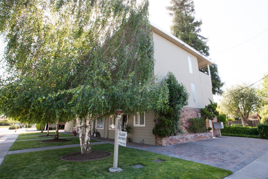 the front of a house with a yard and trees