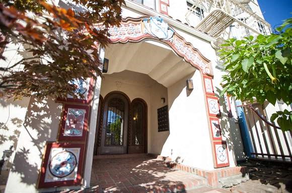 a white building with a door and a tree