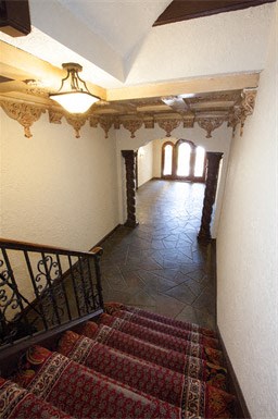 a hallway with a staircase and a rug