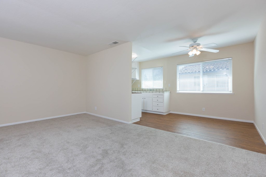 a bedroom with white walls and a ceiling fan