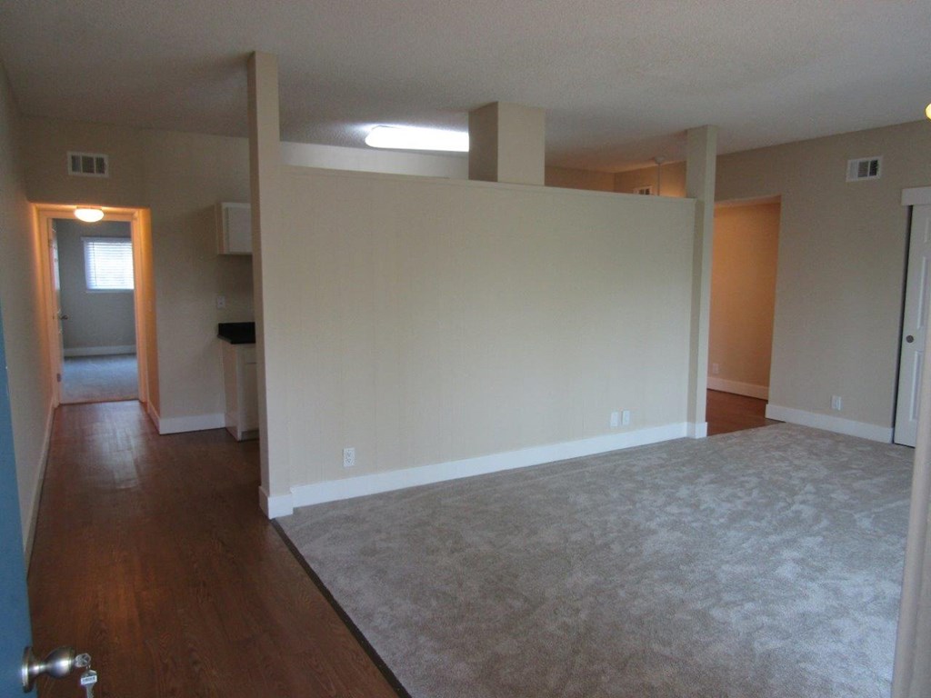 an empty living room with white walls and a carpet