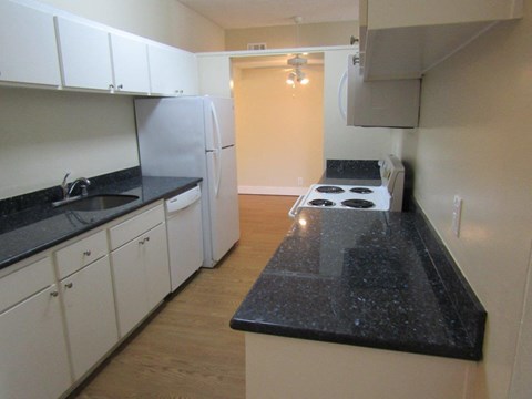 a kitchen with white cabinets and black counter tops
