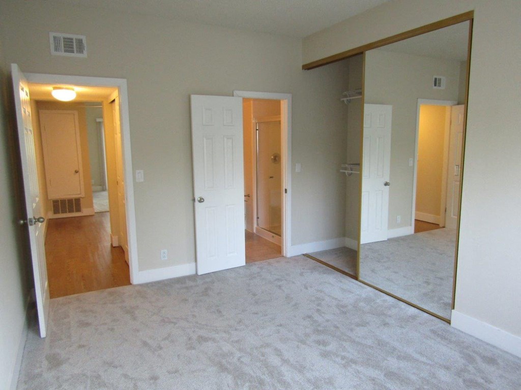 an empty living room with many doors and a carpet