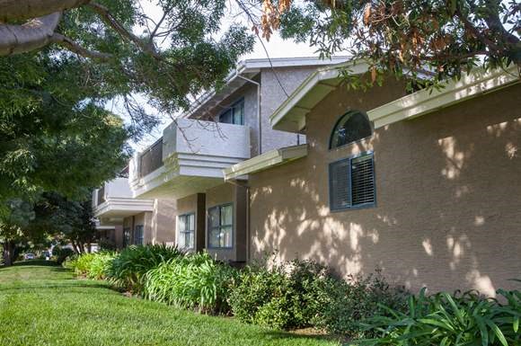 a beige house with a window and a lawn