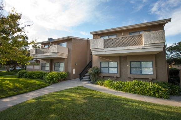 an apartment building with a sidewalk in front of it