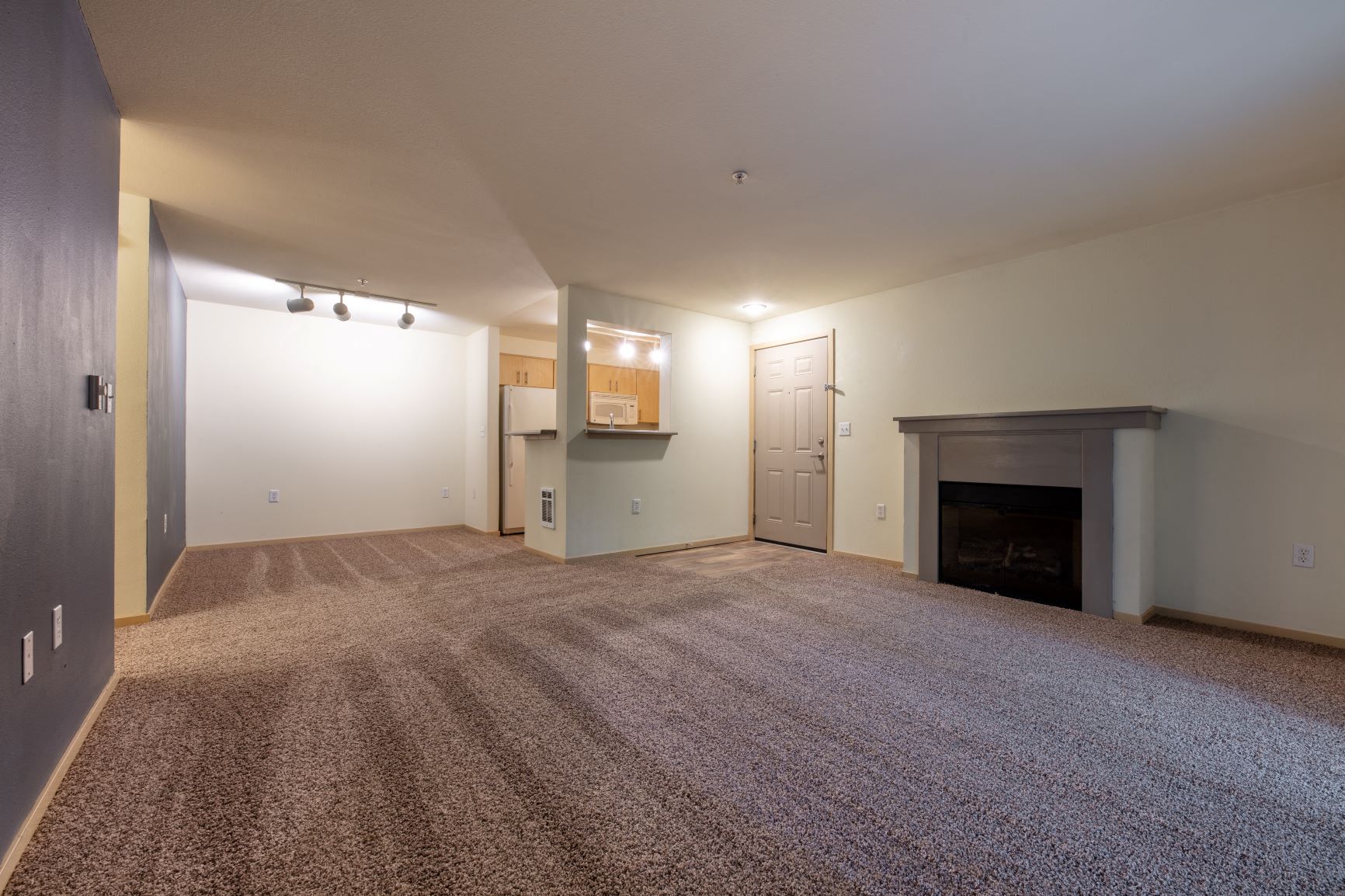 a living room with a fireplace and a carpeted floor