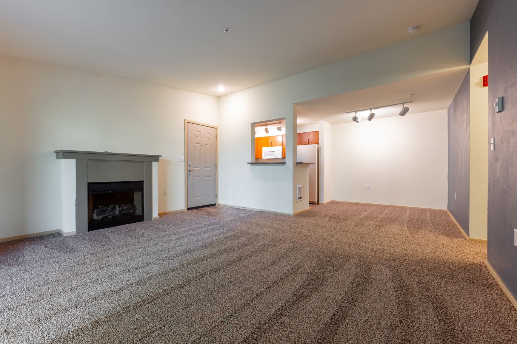 a living room with a fireplace and a carpeted floor