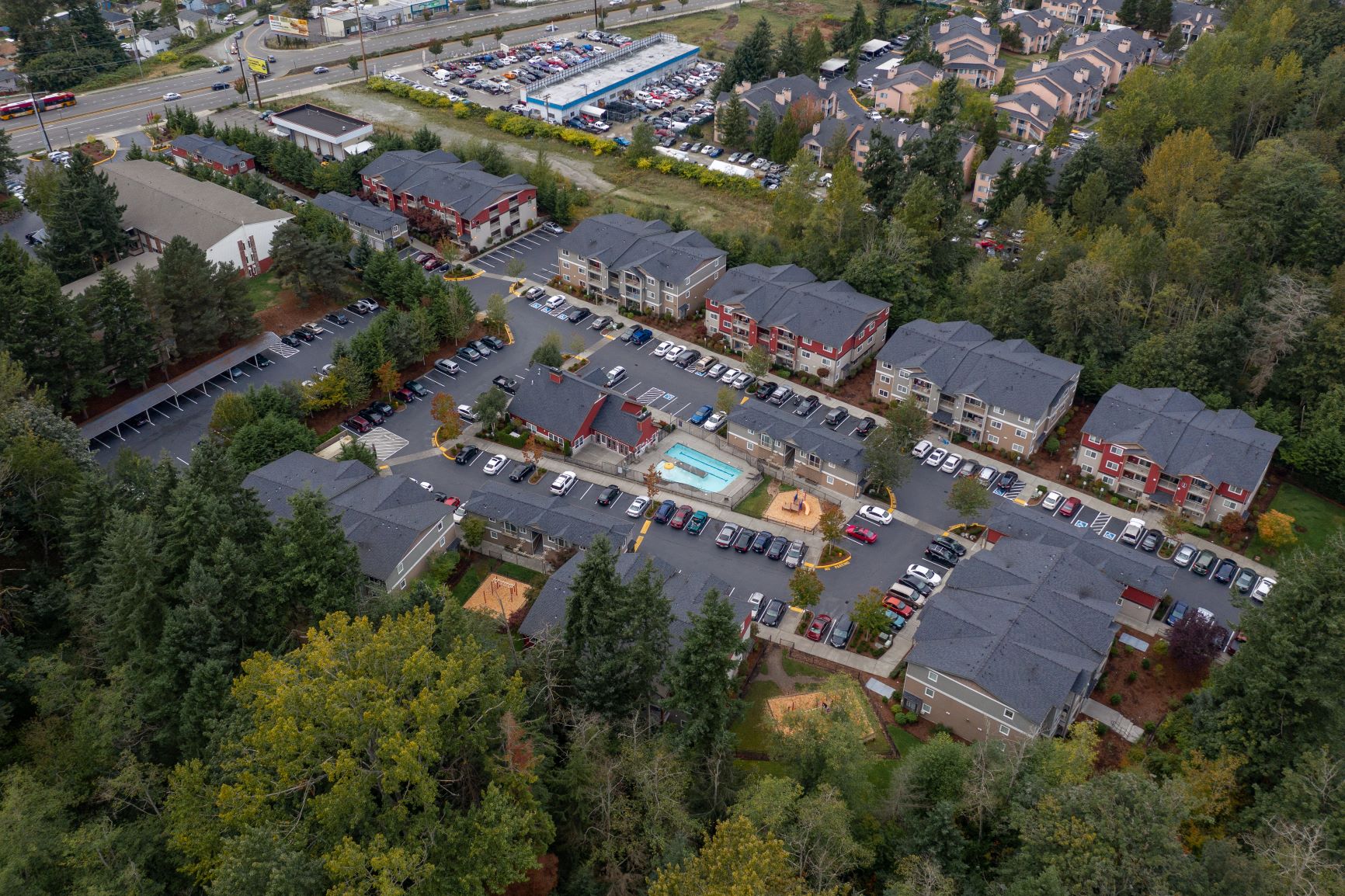 an aerial view of a parking lot with cars and buildings