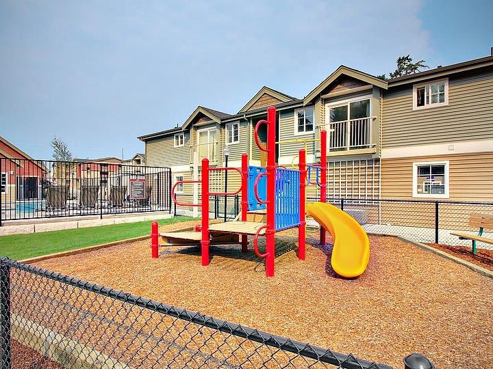 a playground with a blue and yellow swing set