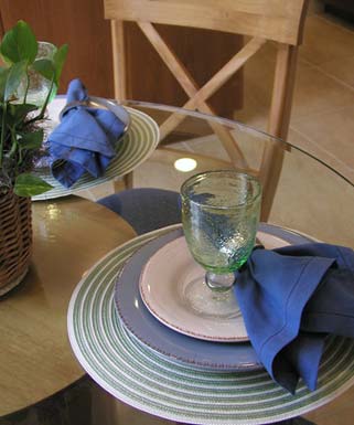 A glass of water is on a plate with a blue napkin.