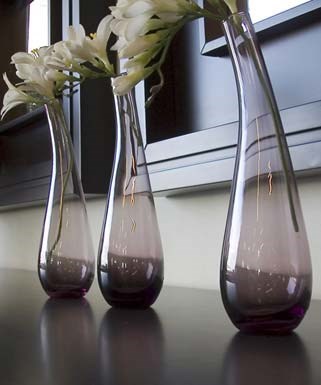 Three vases with flowers in them are sitting on a table.