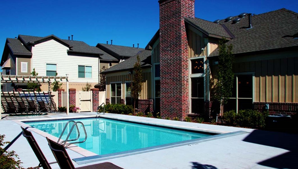 a swimming pool with a house in the background