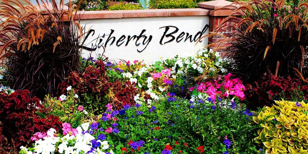 a bunch of colorful flowers in front of a sign