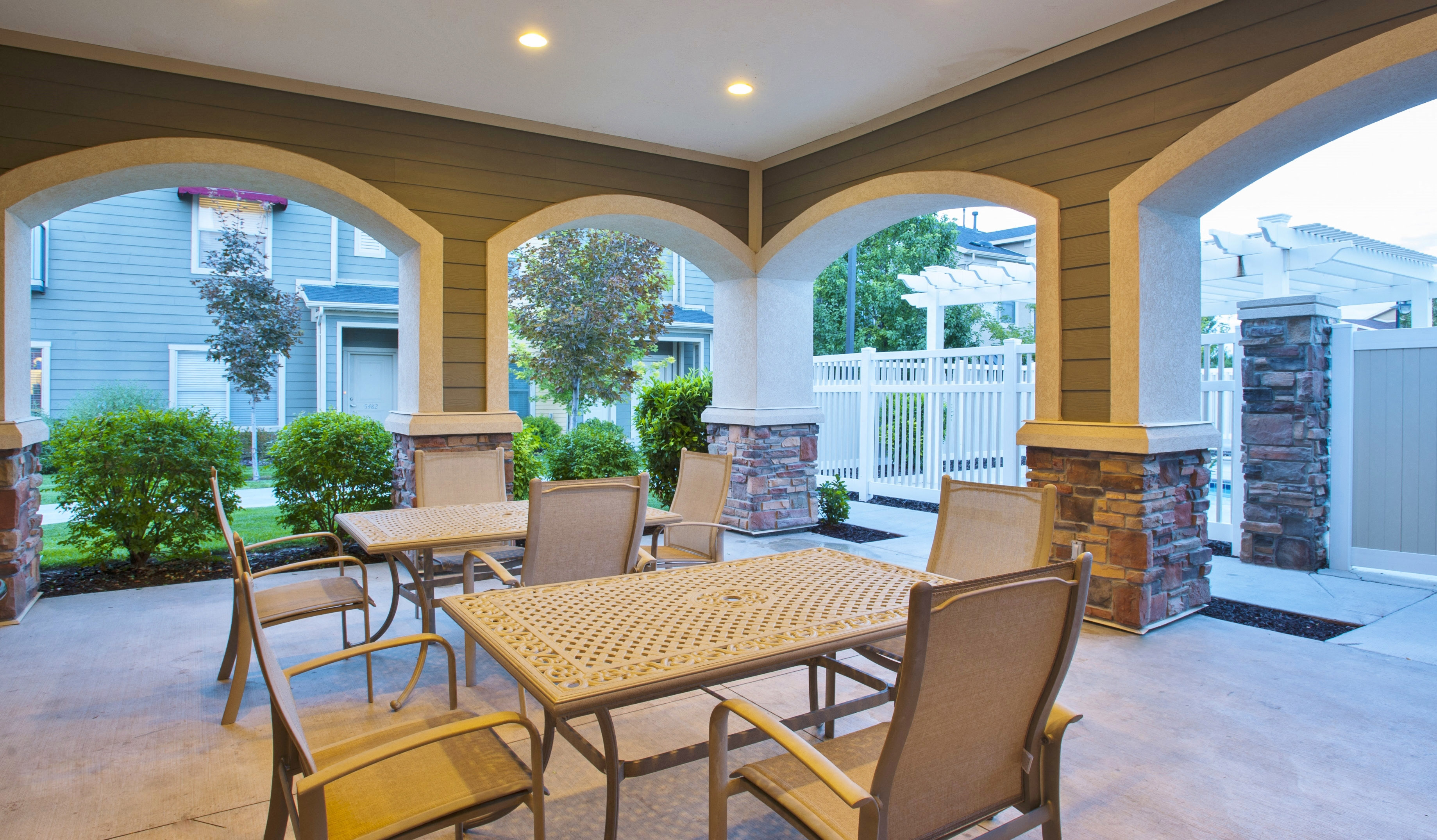 a covered patio with tables and chairs