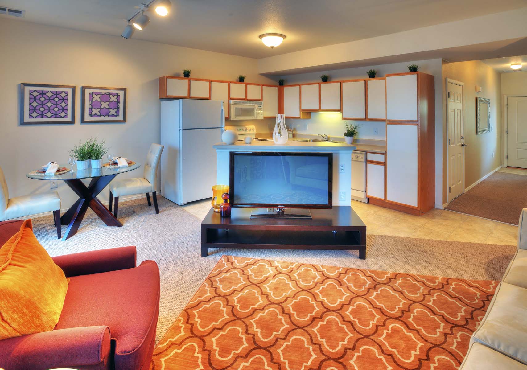 a living room and kitchen with a television