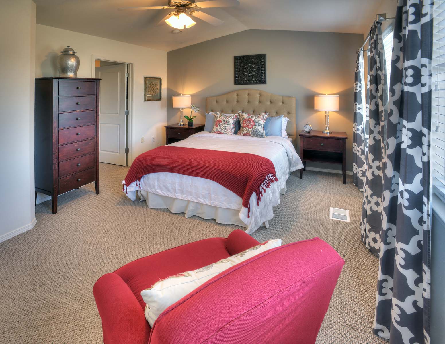 a bedroom with a bed and a red chair