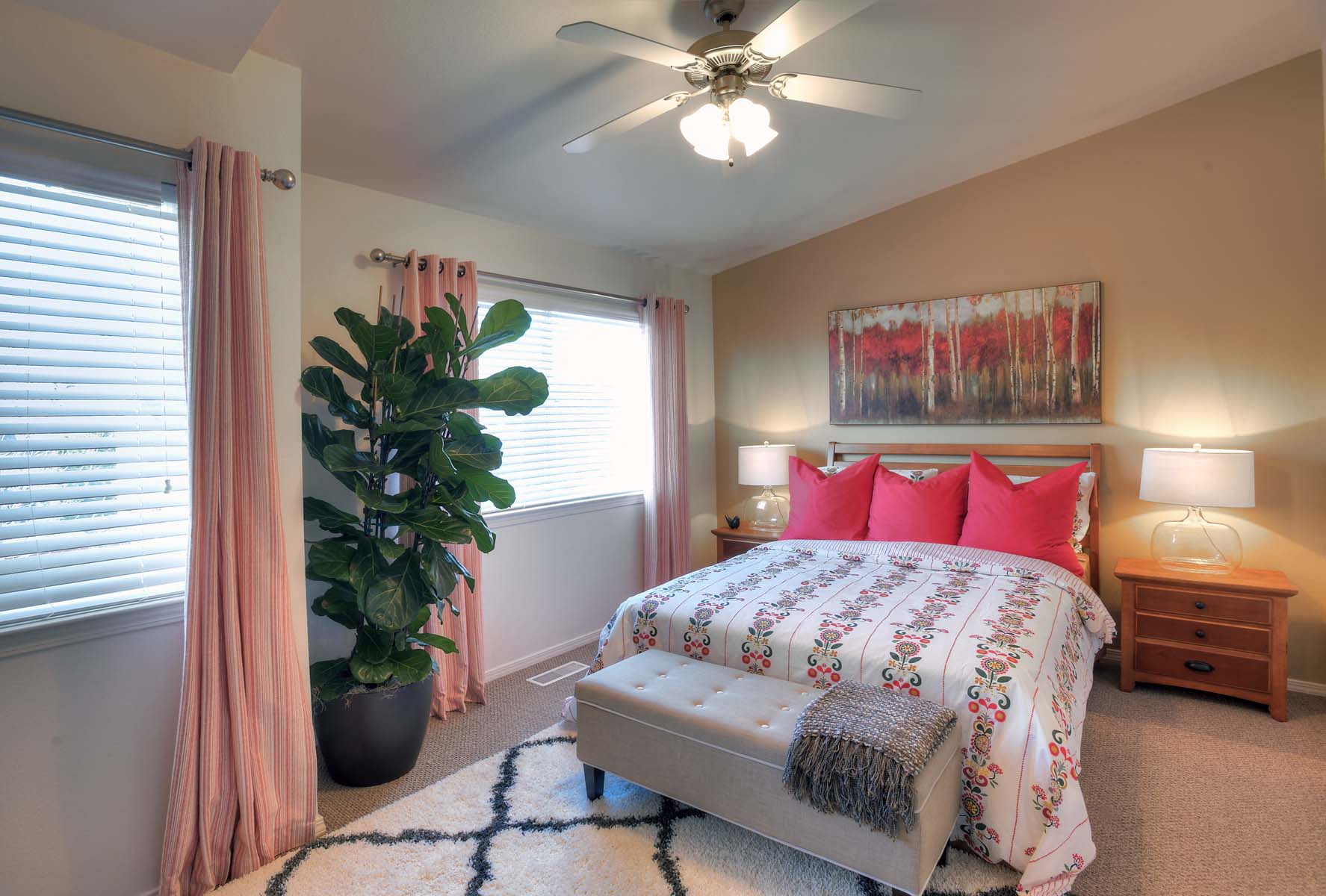 a bedroom with a bed and a plant and a ceiling fan