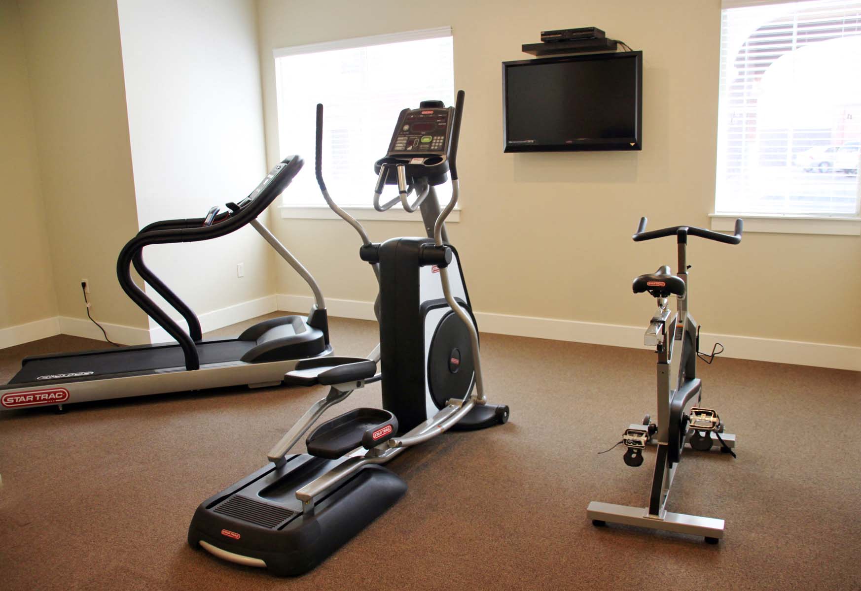 a home gym with exercise equipment and a television