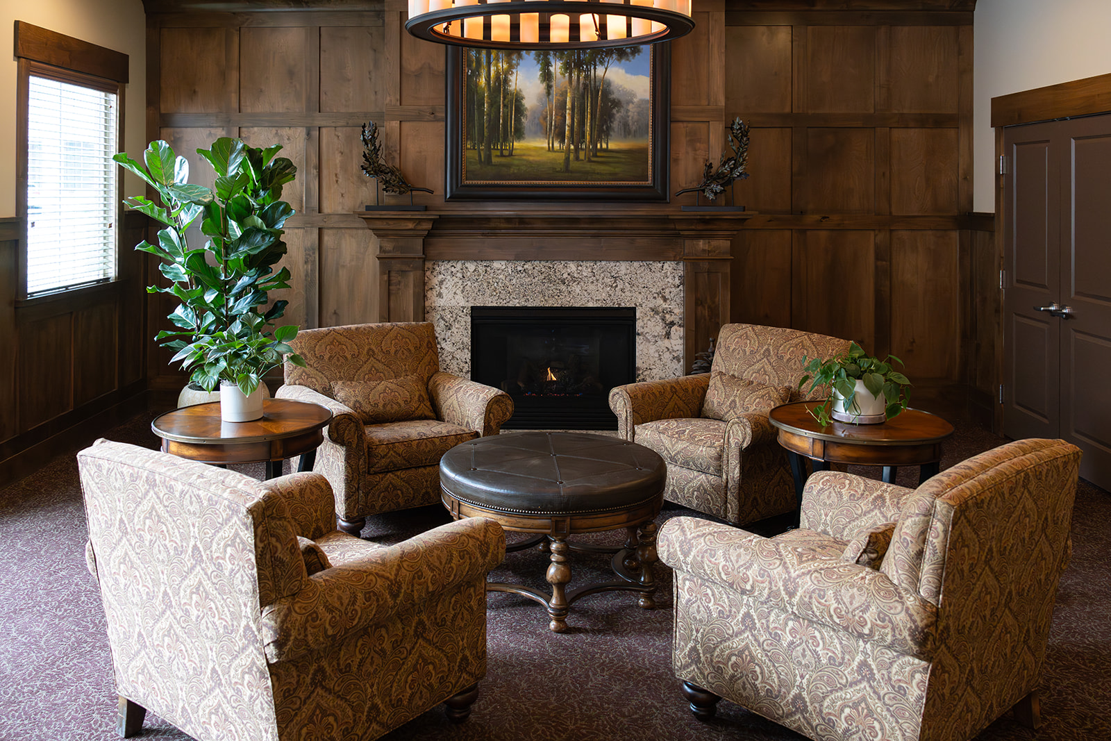 A living room with a fireplace and a painting on the wall.
