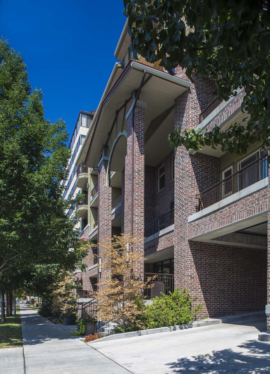 an apartment building with a sidewalk and trees