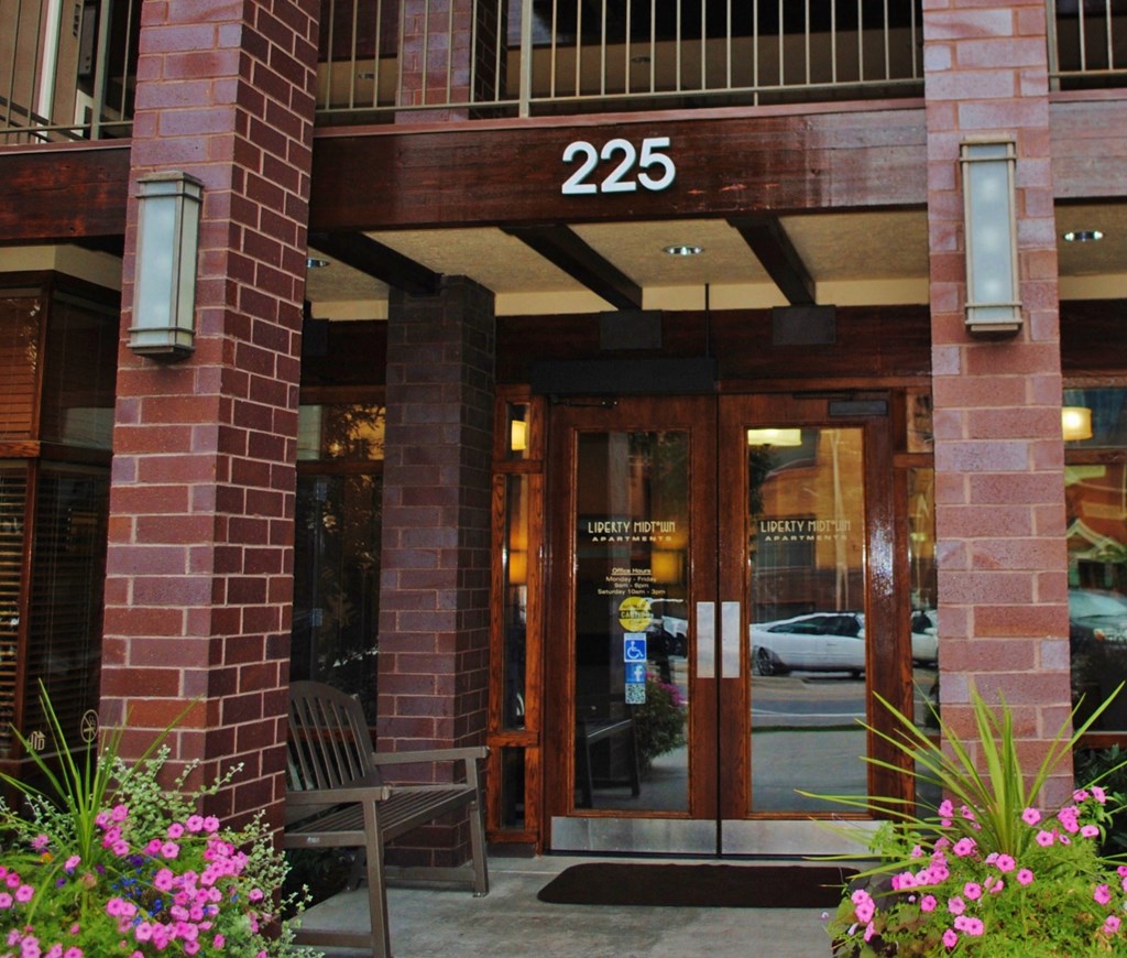 a view of the entrance to a building with doors and a bench